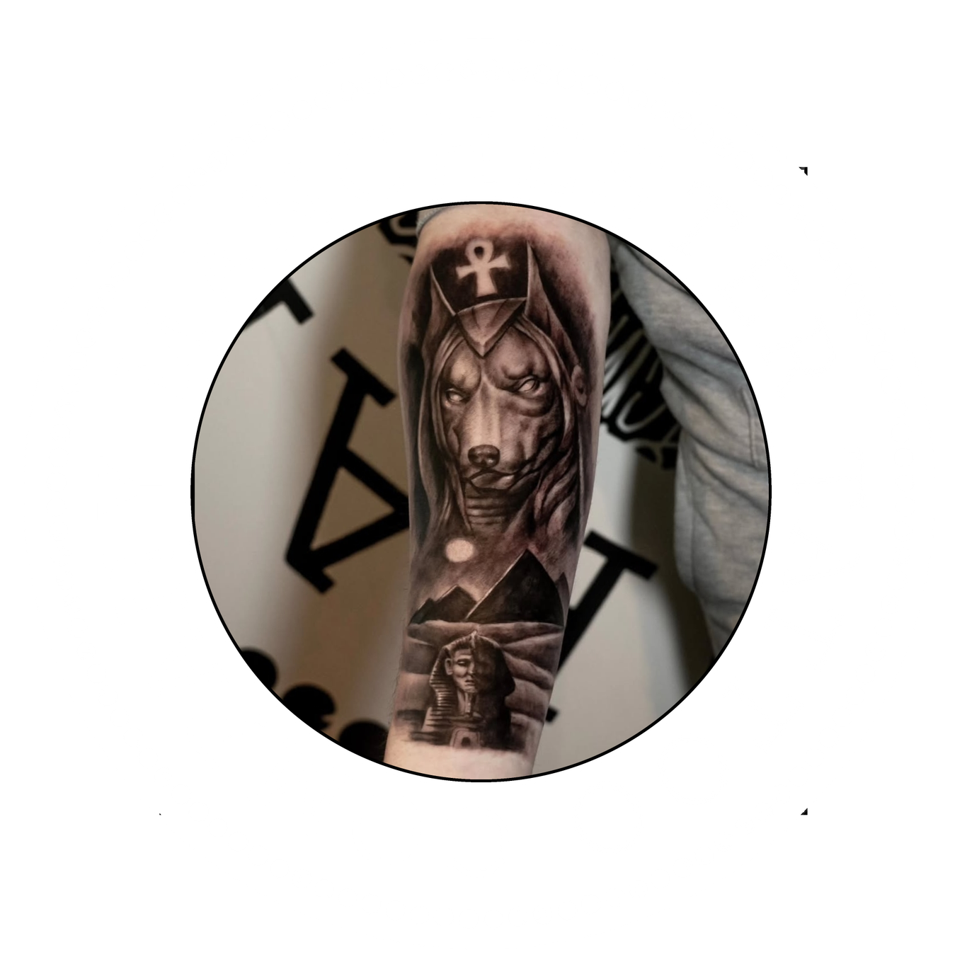 Anubis and the sphinx Infront of the pyramids black and grey tattoo on a forearm.